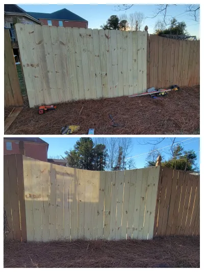 A new section of light-colored pressure-treated wood fence is being installed, contrasting with the older, darker fence panels, with construction tools visible on the pine straw ground.